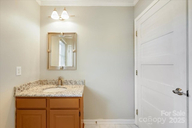 bathroom featuring vanity, baseboards, and crown molding