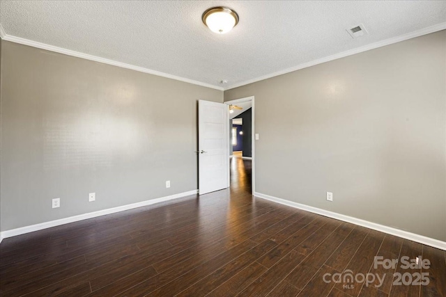 spare room featuring dark wood-type flooring, baseboards, ornamental molding, and a textured ceiling