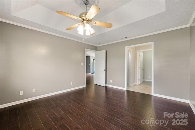 spare room featuring ceiling fan, a textured ceiling, ornamental molding, wood finished floors, and baseboards
