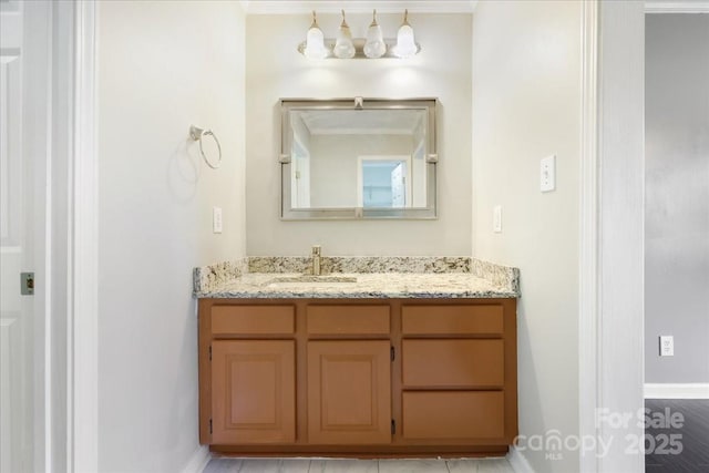 bathroom featuring vanity, baseboards, and ornamental molding