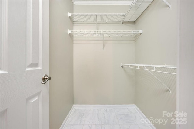 spacious closet featuring marble finish floor