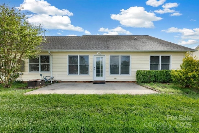 back of property featuring central air condition unit, a shingled roof, a patio area, and a lawn