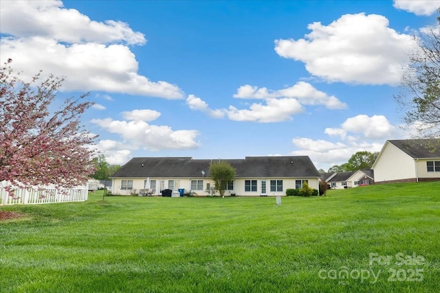 back of house featuring a yard and fence