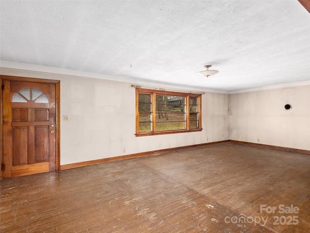 empty room featuring baseboards, a textured ceiling, and hardwood / wood-style floors