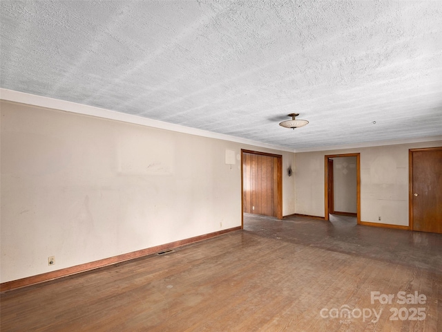 unfurnished room with visible vents, baseboards, hardwood / wood-style floors, and a textured ceiling