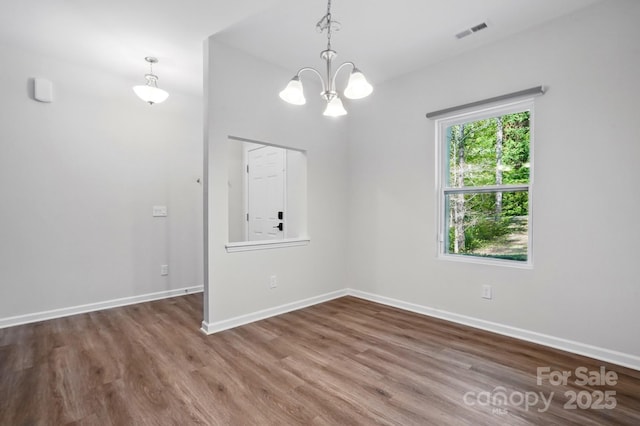 11040 E Lake Rd, Charlotte, NC 28215 - spare room with a notable chandelier, baseboards, visible vents, and wood finished floors