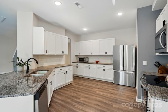 11040 E Lake Rd, Charlotte, NC 28215 - kitchen featuring visible vents, stone countertops, a sink, stainless steel appliances, and decorative backsplash