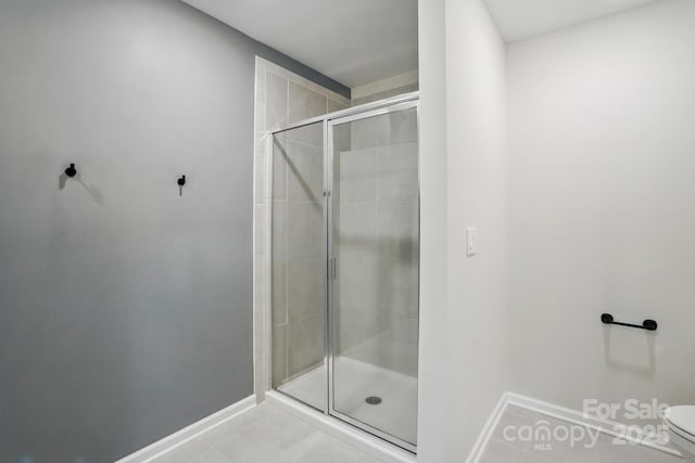 11040 E Lake Rd, Charlotte, NC 28215 - full bathroom featuring toilet, tile patterned floors, baseboards, and a stall shower
