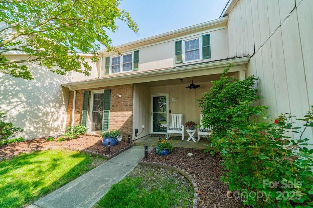 6809 Copernicus Cir, Charlotte, NC 28226 - doorway to property with ceiling fan, covered porch, and brick siding