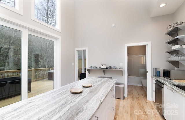 8061 State Highway 80 S, Burnsville, NC 28714 - interior space featuring light stone countertops, a towering ceiling, open shelves, white cabinets, and appliances with stainless steel finishes