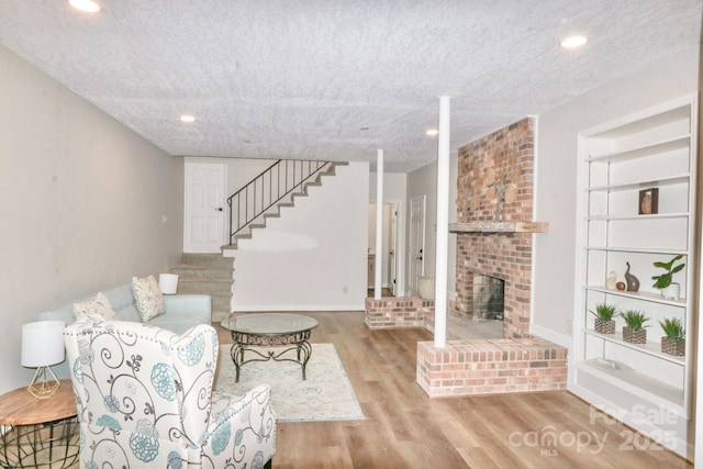 125 Dutchman Creek Rd, Elkin, NC 28621 - living room with wood finished floors, stairway, baseboards, a brick fireplace, and recessed lighting