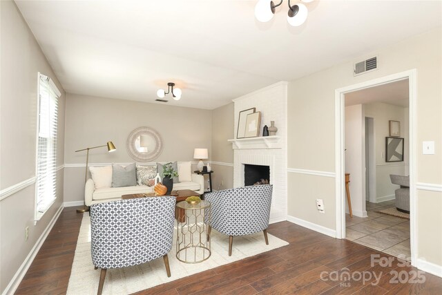 2413 Bergen Ct, Charlotte, NC 28210 - living room with a brick fireplace, wood finished floors, visible vents, and baseboards