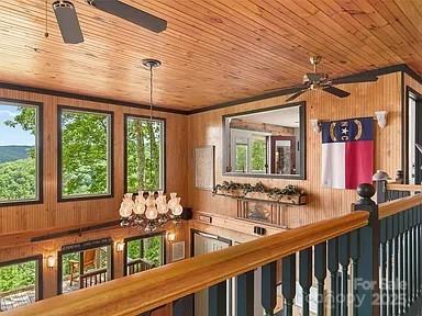 details with wood ceiling, wood walls, and a ceiling fan
