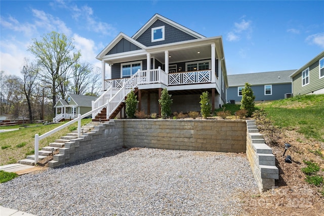 view of front of home with board and batten siding, stairs, and covered porch
