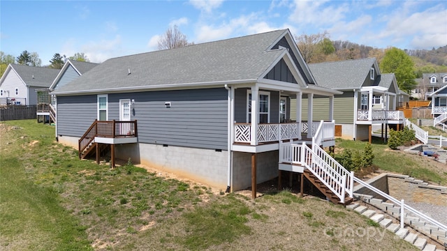 rear view of property with stairs, a residential view, crawl space, a lawn, and roof with shingles