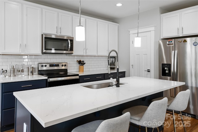 kitchen featuring decorative light fixtures, tasteful backsplash, appliances with stainless steel finishes, and a breakfast bar area