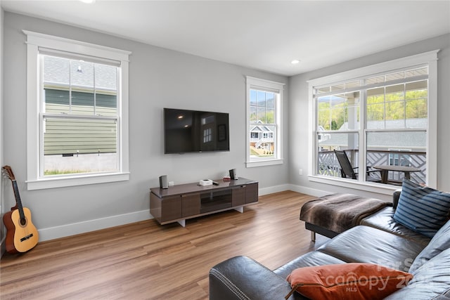 living room with recessed lighting, light wood-type flooring, and baseboards