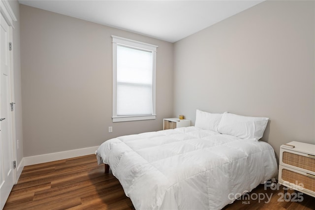 bedroom with baseboards and wood finished floors