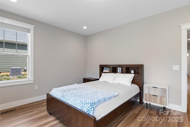 bedroom featuring baseboards, wood finished floors, visible vents, and recessed lighting