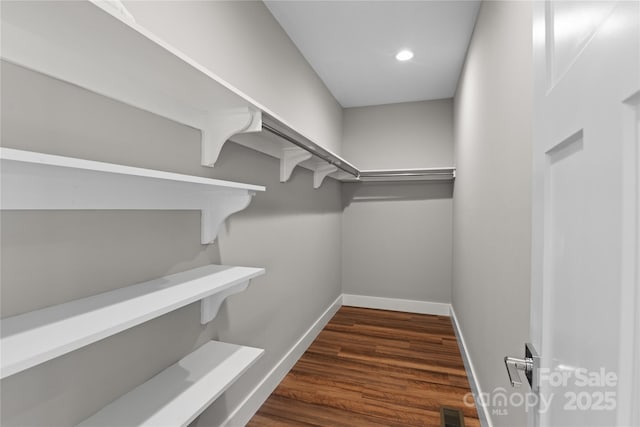 spacious closet featuring visible vents and dark wood-style floors