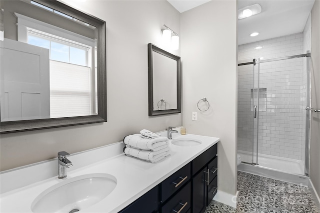 bathroom featuring double vanity, a shower stall, toilet, and a sink