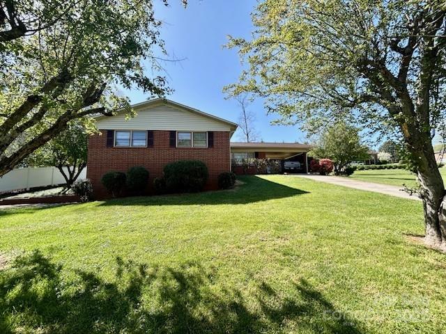 1026 Garden St SE, Lenoir, NC 28645 - view of property exterior featuring concrete driveway, brick siding, an attached carport, and a lawn