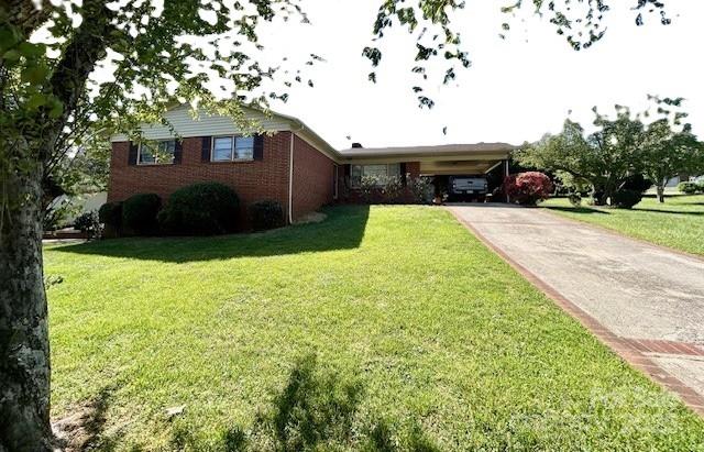 1026 Garden St SE, Lenoir, NC 28645 - view of front of home featuring driveway, an attached carport, a front lawn, and brick siding