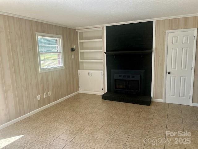 1026 Garden St SE, Lenoir, NC 28645 - unfurnished living room featuring crown molding, a fireplace, a textured ceiling, baseboards, and built in shelves
