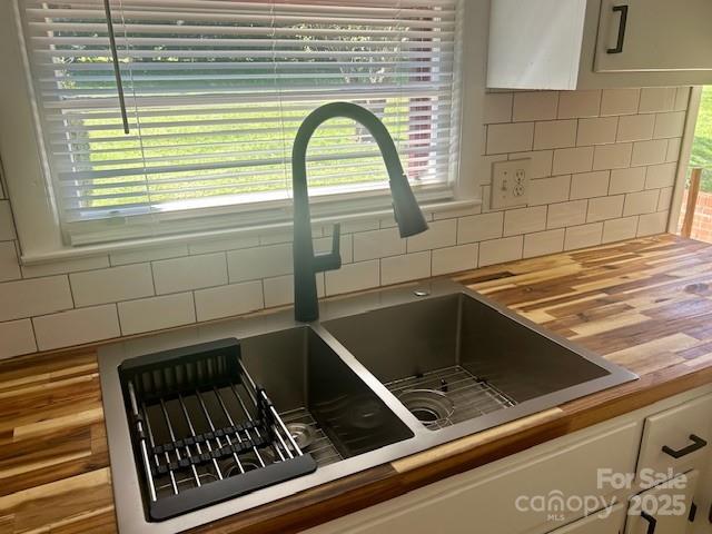 1026 Garden St SE, Lenoir, NC 28645 - details with a sink, wooden counters, tasteful backsplash, and white cabinetry