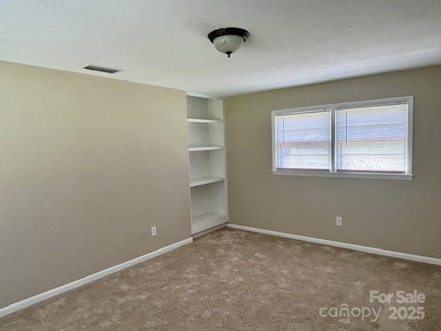 1026 Garden St SE, Lenoir, NC 28645 - empty room featuring a textured ceiling, baseboards, carpet, and visible vents