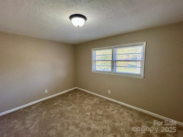 1026 Garden St SE, Lenoir, NC 28645 - carpeted spare room with baseboards and a textured ceiling