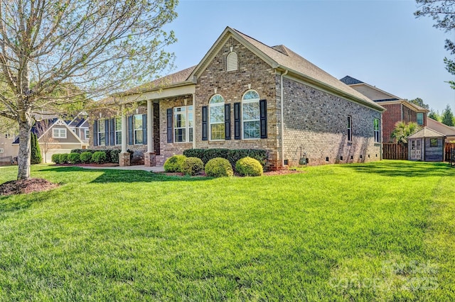 view of front facade featuring a front yard, brick siding, and crawl space