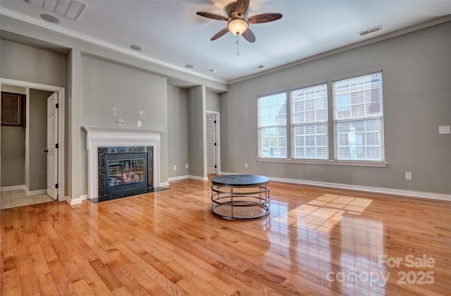 unfurnished living room featuring wood finished floors, a fireplace, a ceiling fan, and visible vents