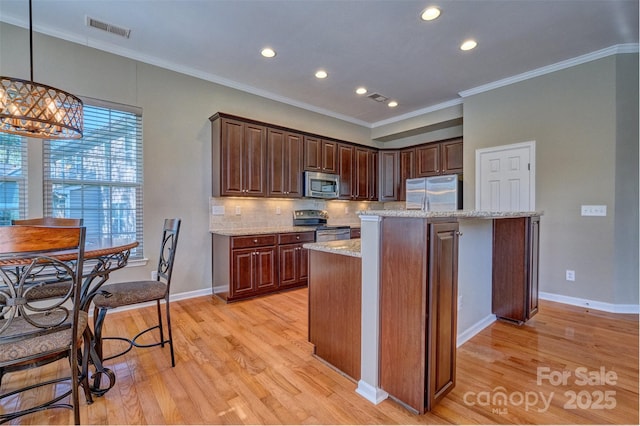 kitchen featuring light wood-style floors, crown molding, visible vents, appliances with stainless steel finishes, and decorative backsplash