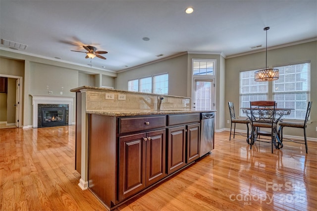 kitchen featuring ceiling fan with notable chandelier, stainless steel dishwasher, light wood-type flooring, visible vents, and a sink