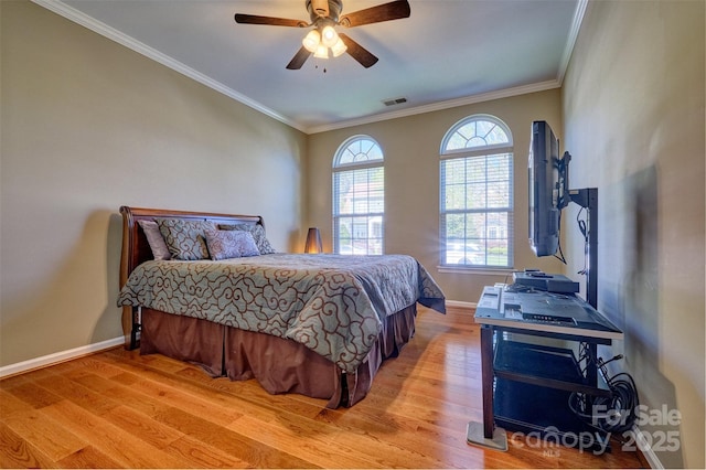 bedroom featuring baseboards, crown molding, visible vents, ceiling fan, and light wood finished floors