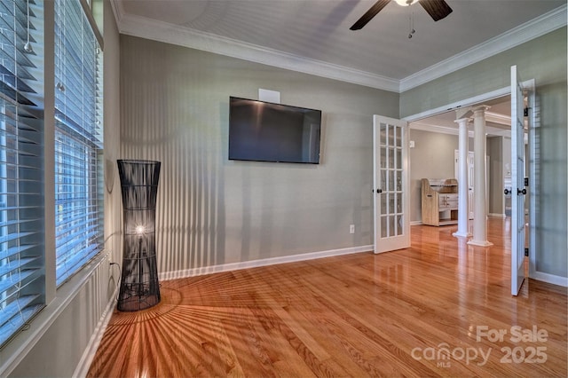 unfurnished living room featuring decorative columns, ornamental molding, a ceiling fan, wood finished floors, and french doors