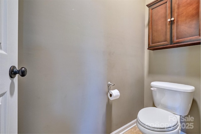 bathroom with toilet and baseboards