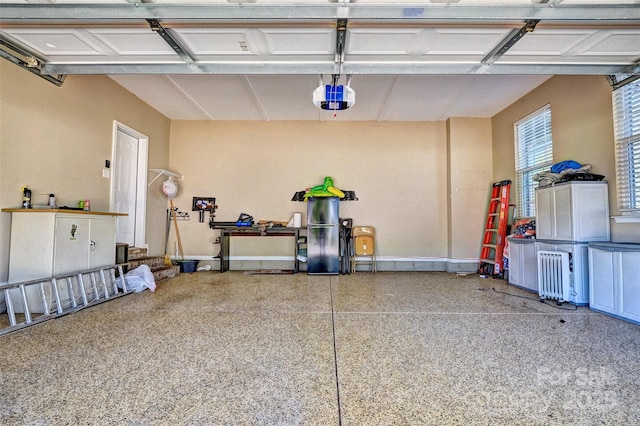 garage featuring a garage door opener and baseboards