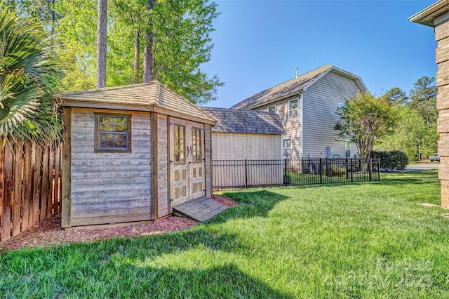 view of yard featuring an outdoor structure, fence, and a shed