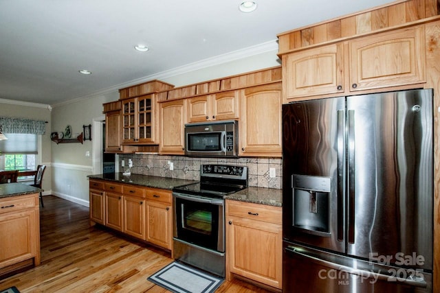 kitchen featuring tasteful backsplash, crown molding, light wood-style flooring, glass insert cabinets, and appliances with stainless steel finishes
