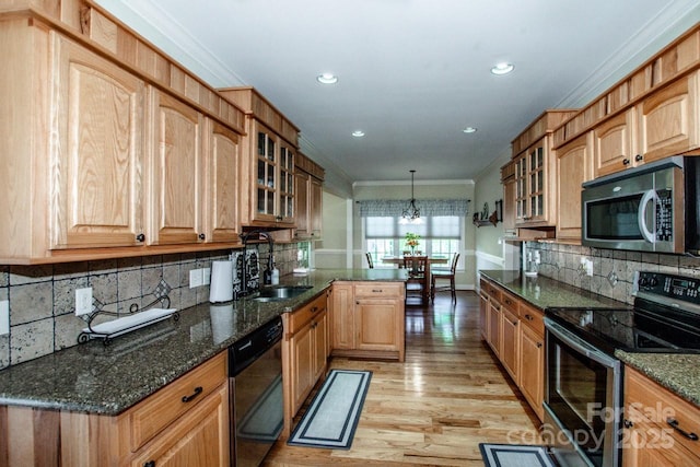 kitchen with a sink, stainless steel appliances, light wood-type flooring, a peninsula, and backsplash