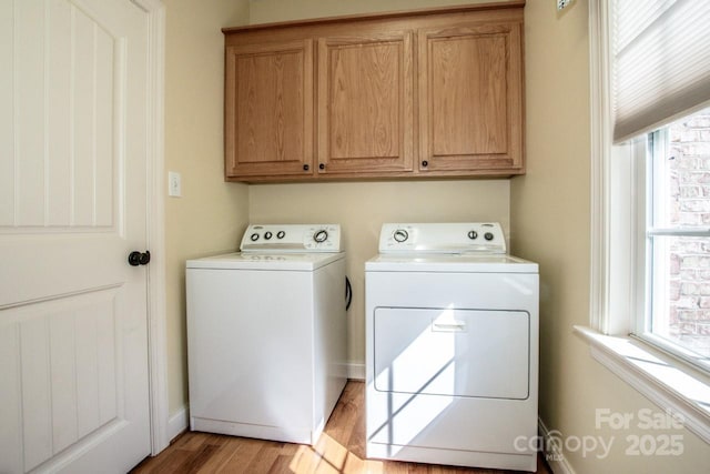 laundry area with cabinet space, washing machine and clothes dryer, and light wood-style flooring