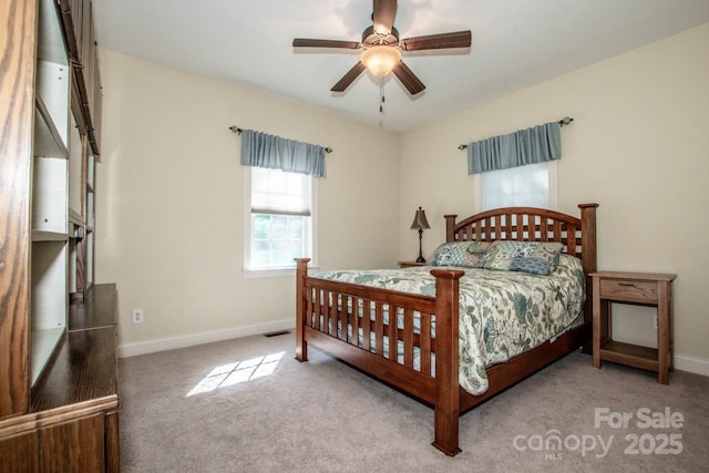 carpeted bedroom featuring baseboards, visible vents, and a ceiling fan