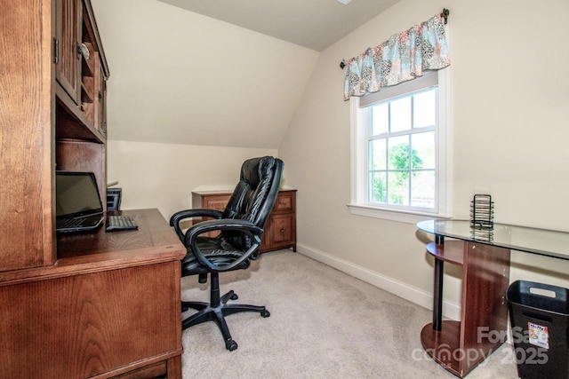 office space featuring baseboards, light colored carpet, and vaulted ceiling