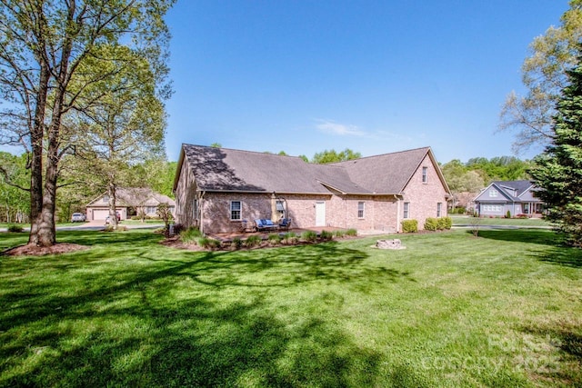 back of house with a yard and brick siding