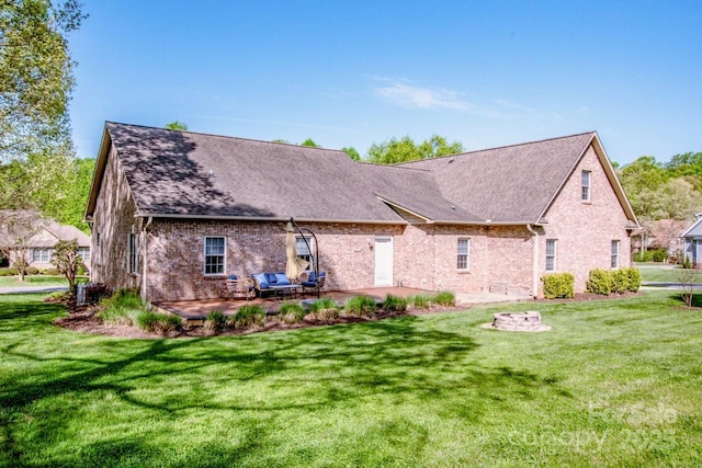 rear view of property with a yard, a patio, brick siding, and a shingled roof