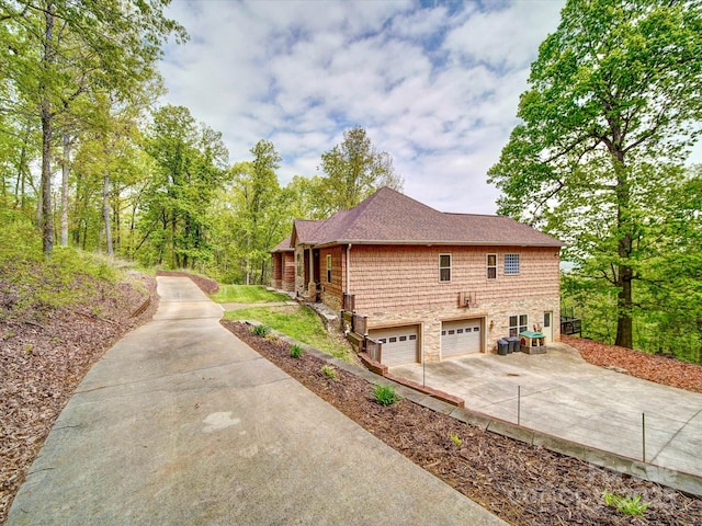 135 Boulder Ridge Dr, Denton, NC 27239 - view of home's exterior with concrete driveway, stone siding, a garage, and a shingled roof