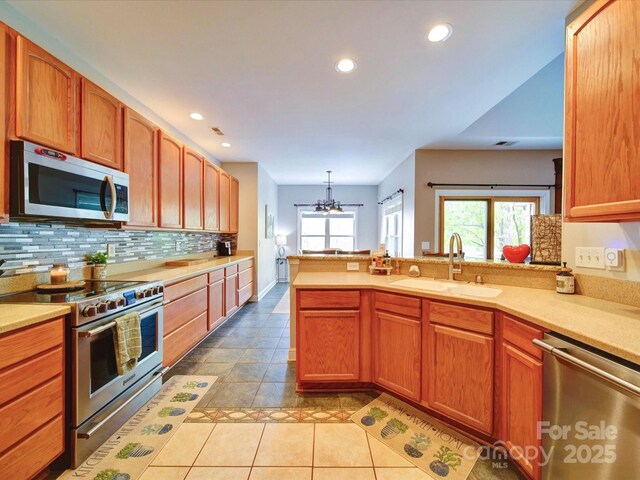 135 Boulder Ridge Dr, Denton, NC 27239 - kitchen with a peninsula, light countertops, backsplash, appliances with stainless steel finishes, and a sink