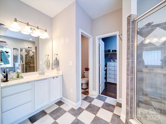 135 Boulder Ridge Dr, Denton, NC 27239 - bathroom with baseboards, toilet, a walk in closet, vanity, and a stall shower